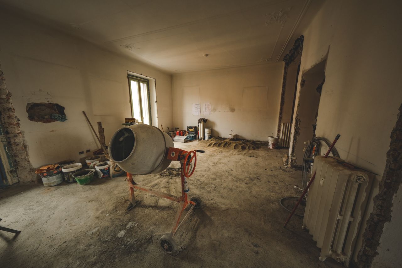 services-03 Empty room with a concrete mixer and tools, ideal for renovation concepts.