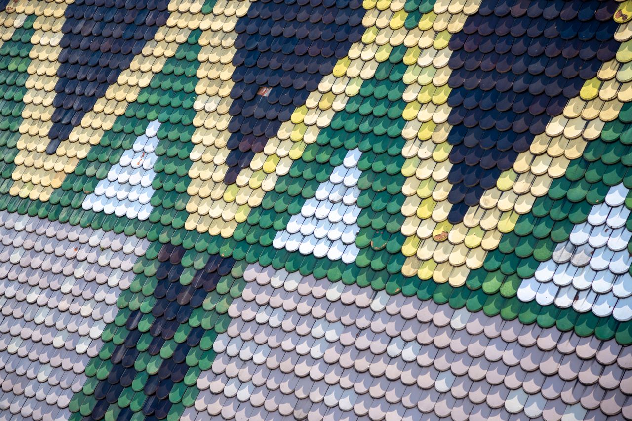 Vibrant geometric tile pattern on European roof showcasing intricate design.
