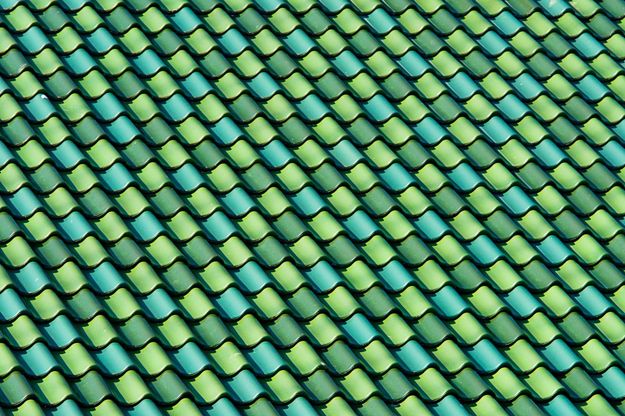 Colorful and symmetrical green tiled rooftop pattern showcasing architectural design elements.